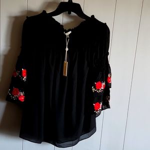 Off the shoulder embroidered blouse. New with tags. Black with pink embroidery.